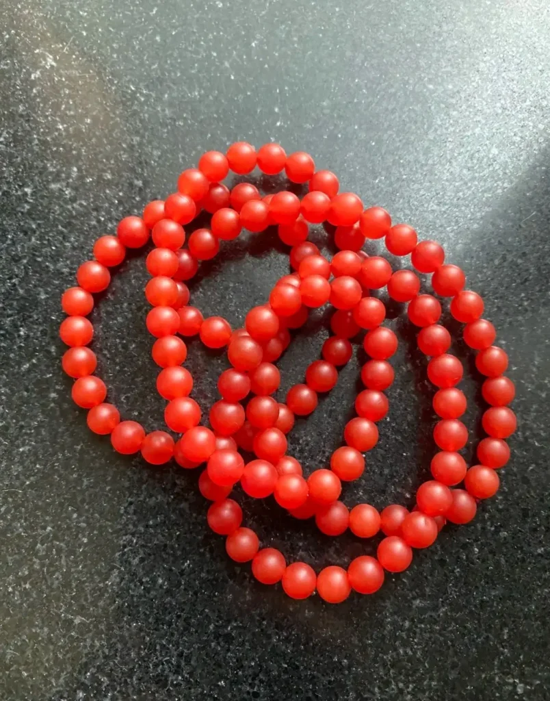 Red dyed quartzite bead strand with honeycomb color distribution mimicking Nanhong Agate.