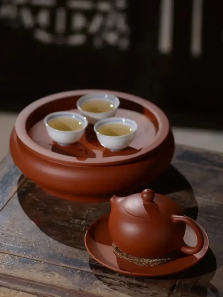 A traditional Kung Fu tea set on a table with tea poured into a ceramic cup.