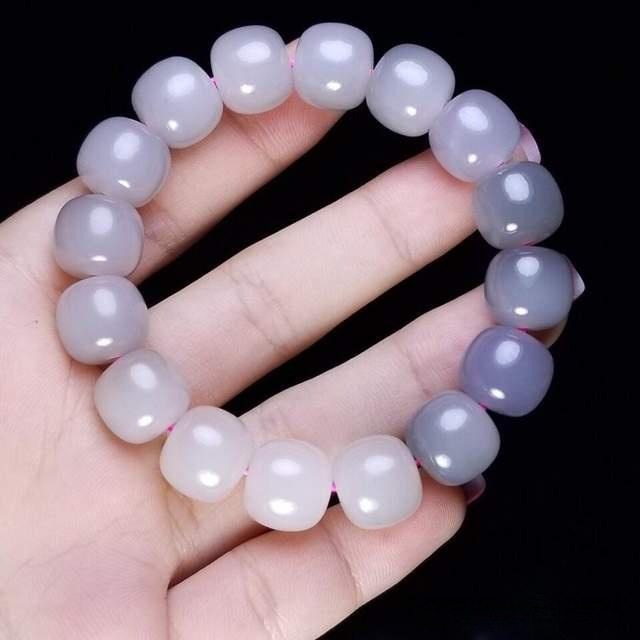 Gradient color bead bracelet threaded on a vibrant purple cord to create a visual bleeding effect.