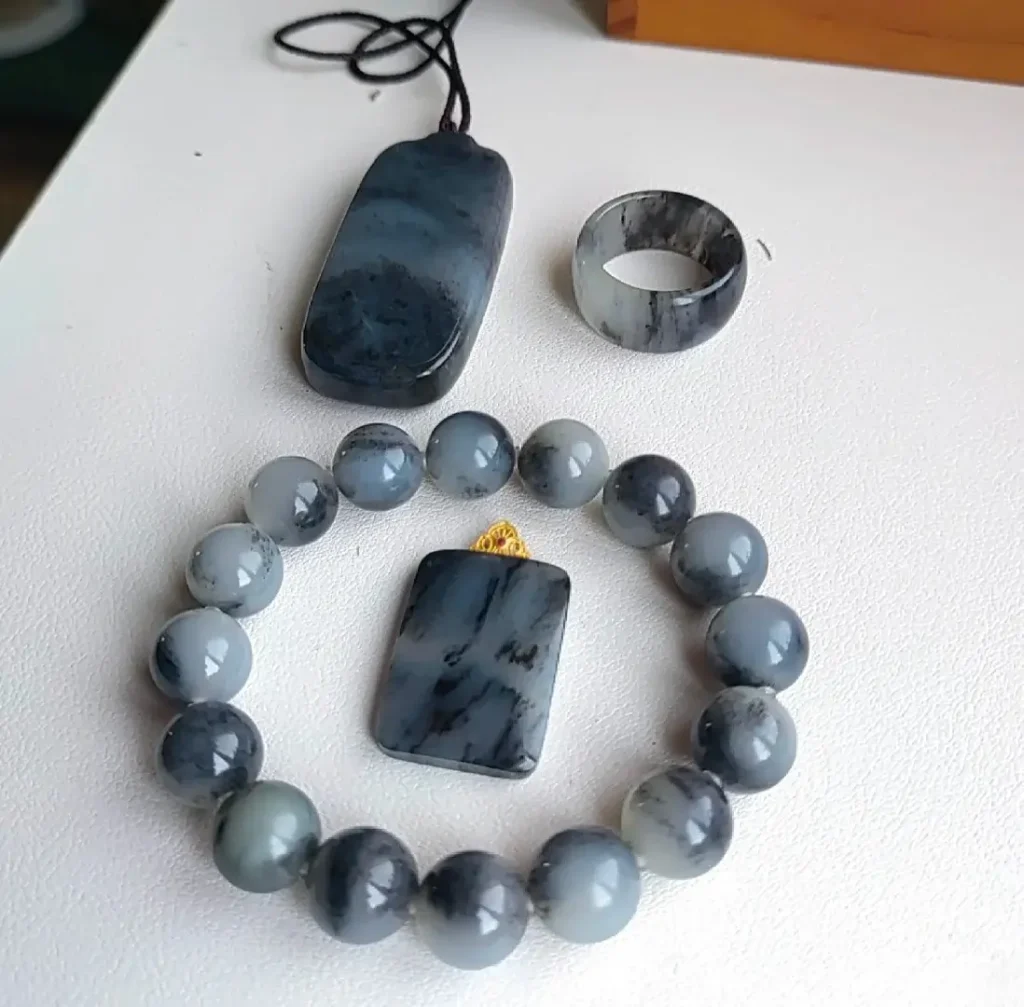 Qinghua Nephrite jewelry set including a pendant, ring, and bangle with natural black and white ink patterns.