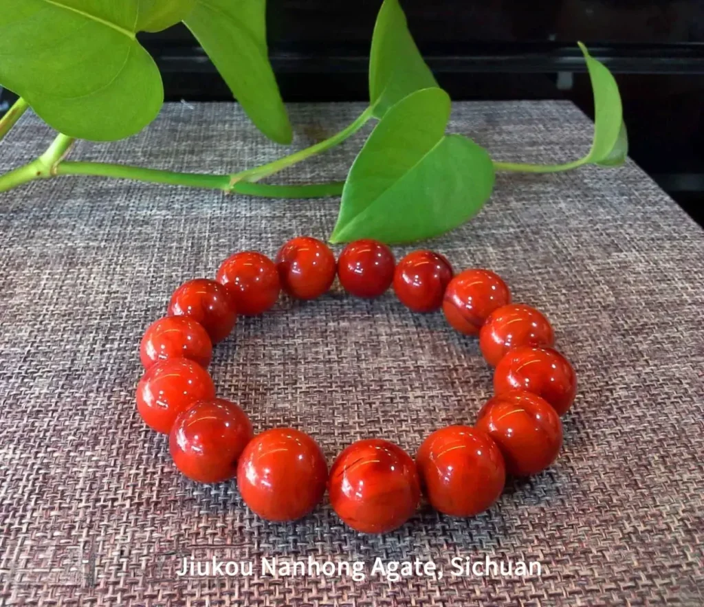 Jiukou Nanhong agate bead bracelet from Sichuan featuring dense persimmon and flame patterns.