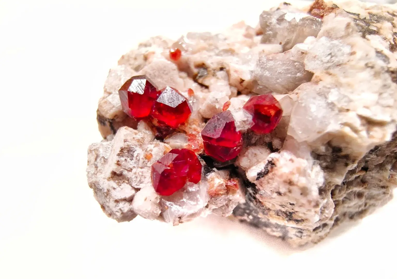 Five red garnet crystals embedded in natural host rock from Mingxi, Fujian.