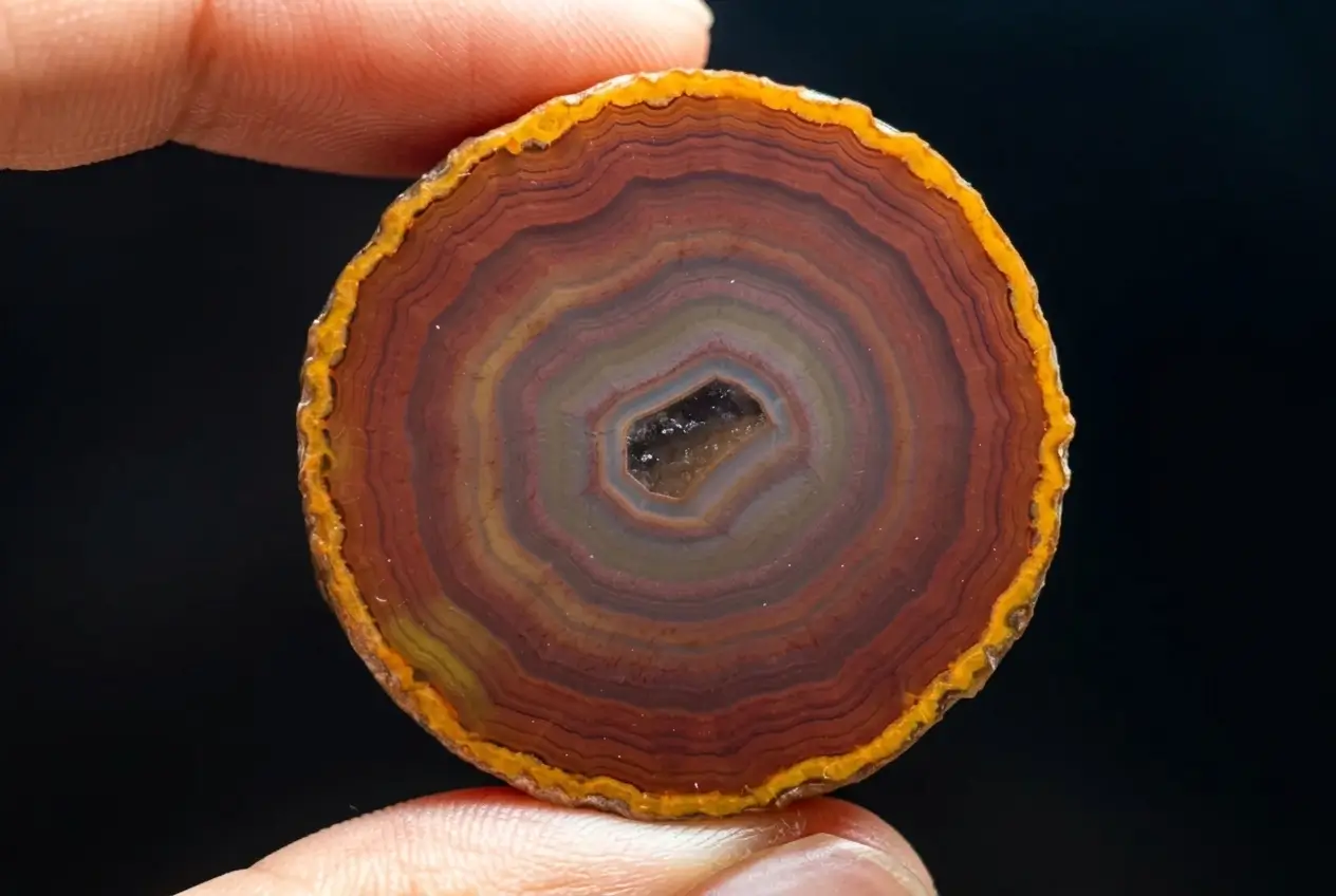Close-up of a polished Xuanhua Zhan-Guo Red agate slice from Hebei, featuring concentric rings.