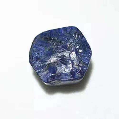 A raw Fujian sapphire crystal showing a characteristic barrel shape and vitreous luster.