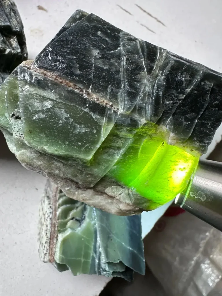 Raw specimen of Longxi Jade showing tremolite-rich texture and natural fractures.