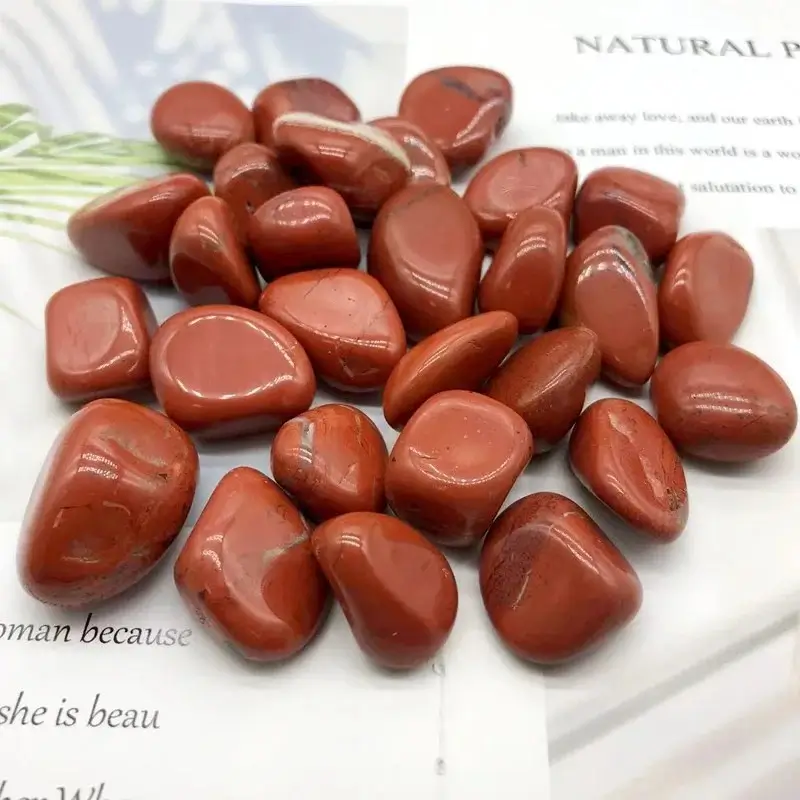 Group of raw Red Jasper stones showing opaque, earthy red texture and brownish-red tones.