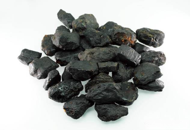 A group of dark, unpolished raw Fushun amber specimens from Liaoning in their natural state.