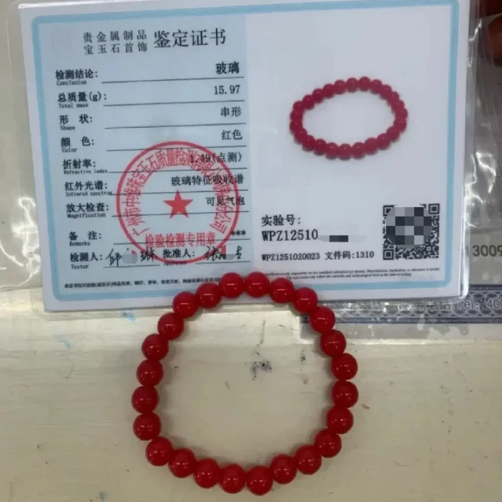 Red glass bead bracelet with an identification certificate, showing high, uniform luster.
