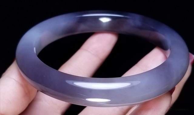 A polished smoky purple nephrite jade bangle with a refined grey-violet hue and smooth oily luster.