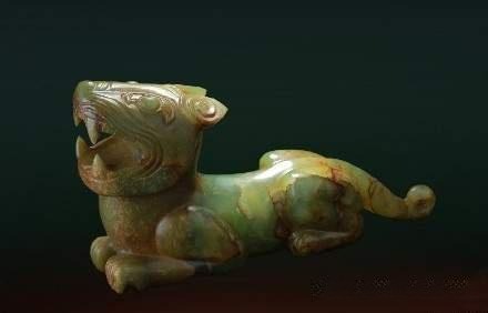 Ancient Sanxingdui jade reclining tiger carved from green Longxi tremolite nephrite.