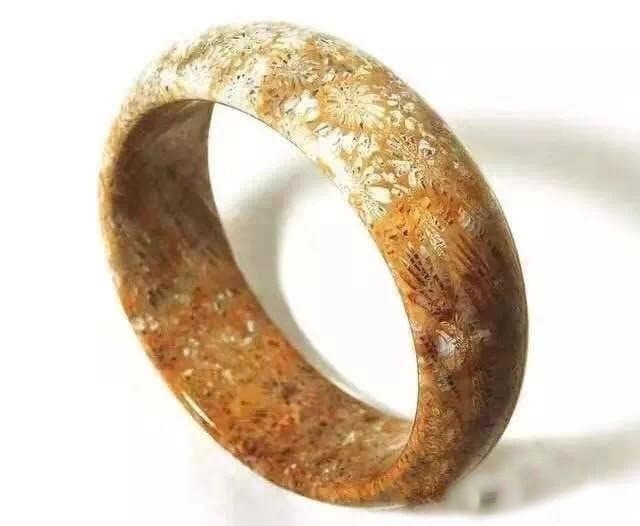 A smooth, plain-surface (su mian) Shaanxi Ningqiang Coral Jade bangle with natural floral patterns.