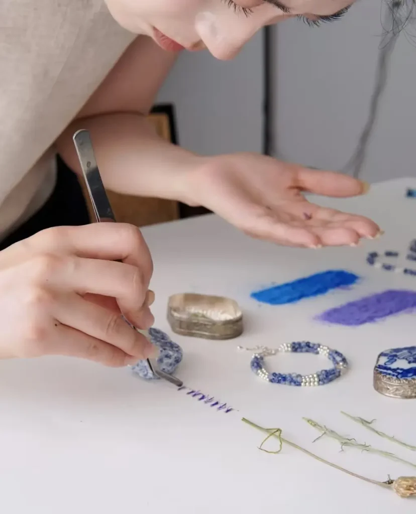 Artisan ShanYu creating nature-inspired handmade earrings at a jewelry bench