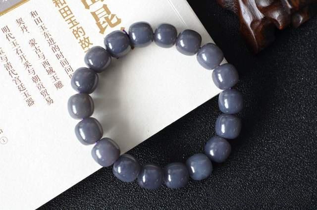 A strand of round smoky purple nephrite beads showing soft grey tones with subtle violet undertones.