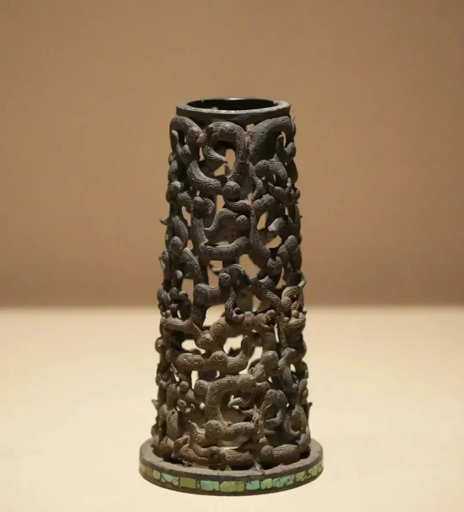 A Warring States openwork bronze censer with a base featuring a circular band of inlaid turquoise.