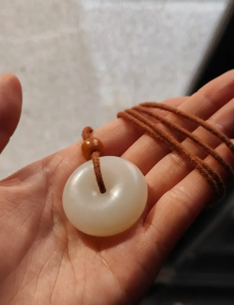 White Hetian jade pendant with a stable, glowing oily patina from daily wear and handling.