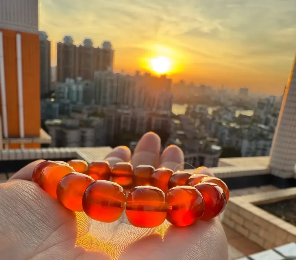 Xunke Beihong agate bead bracelet in palm, showing high transparency under golden hour light.