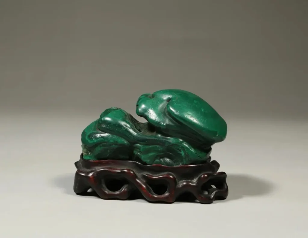 Yangchun malachite scholar stone featuring deep emerald green layers and natural silky luster.