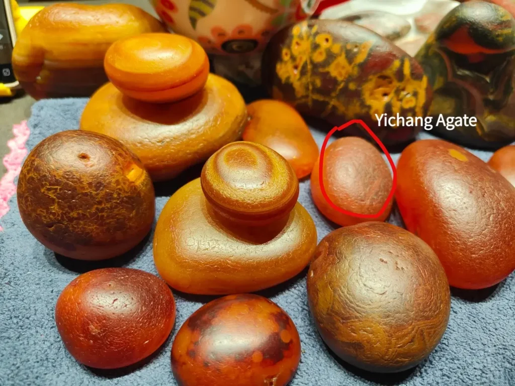 A Hubei Yichang agate circled in red among a cluster of similar Madagascar red agates.