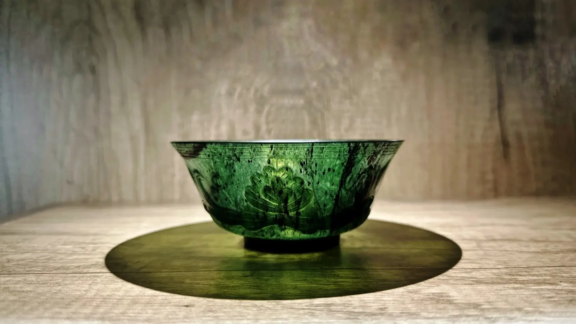 A translucent green Yuanyang Jade bowl from Gansu with natural dark serpentine mottling.