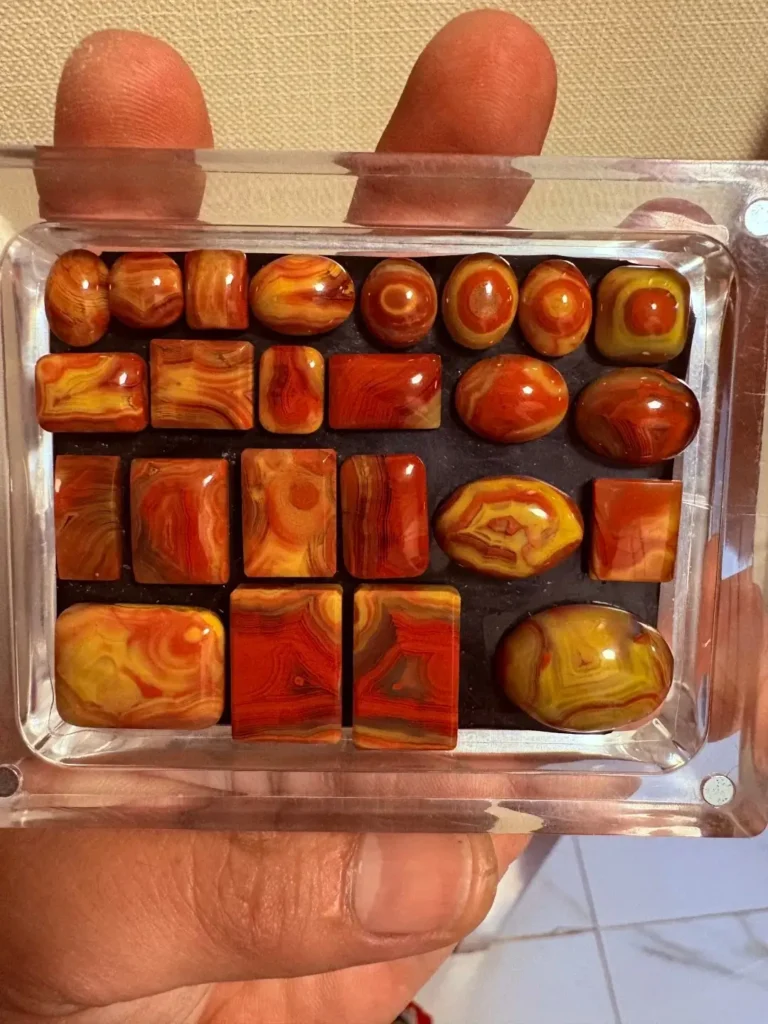 A collection of Zhan-Guo Red agate in various cuts, showing vivid yellow and red banding.
