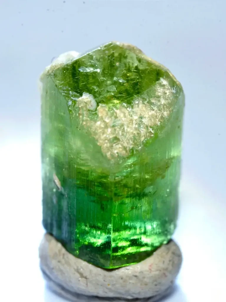 An 8-carat vibrant green tourmaline crystal from Yunnan with a clear prismatic structure.
