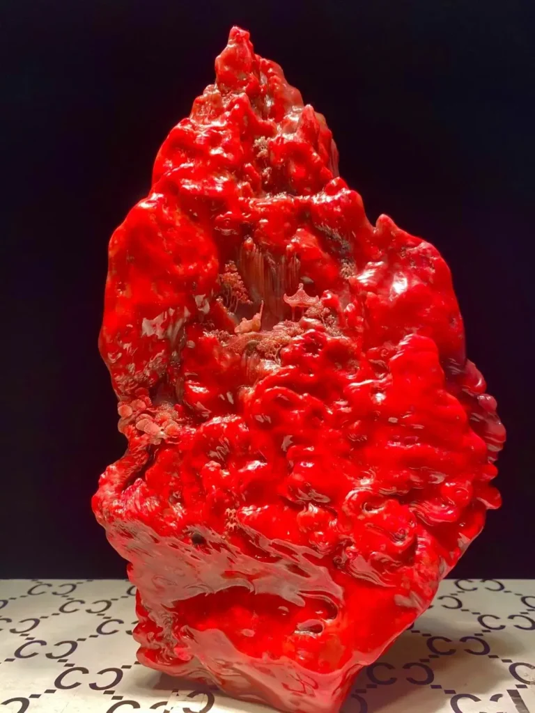 Vibrant red Inner Mongolia Balin chicken-blood stone boulder featuring intricate traditional Chinese pavilion carvings.