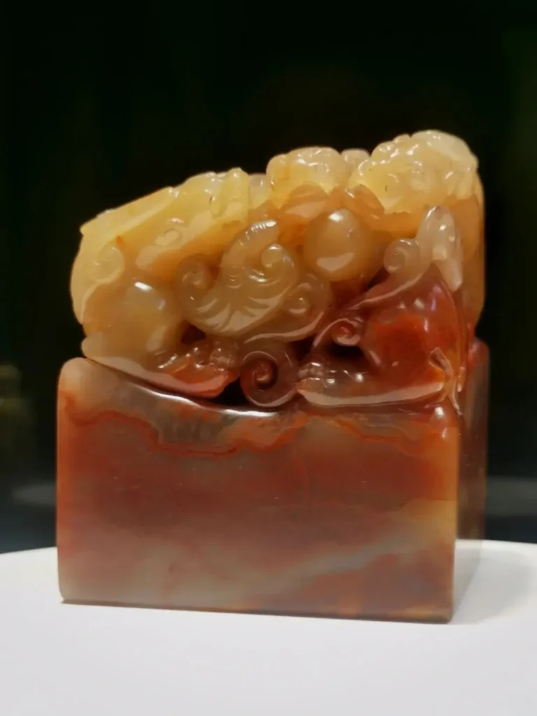 Translucent multi-colored Inner Mongolia Balin jelly stone seal with an intricate mythical carving.
