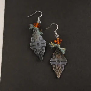 vintage-carved Black Mother of Pearl earrings with radiant orange glass on a black background.