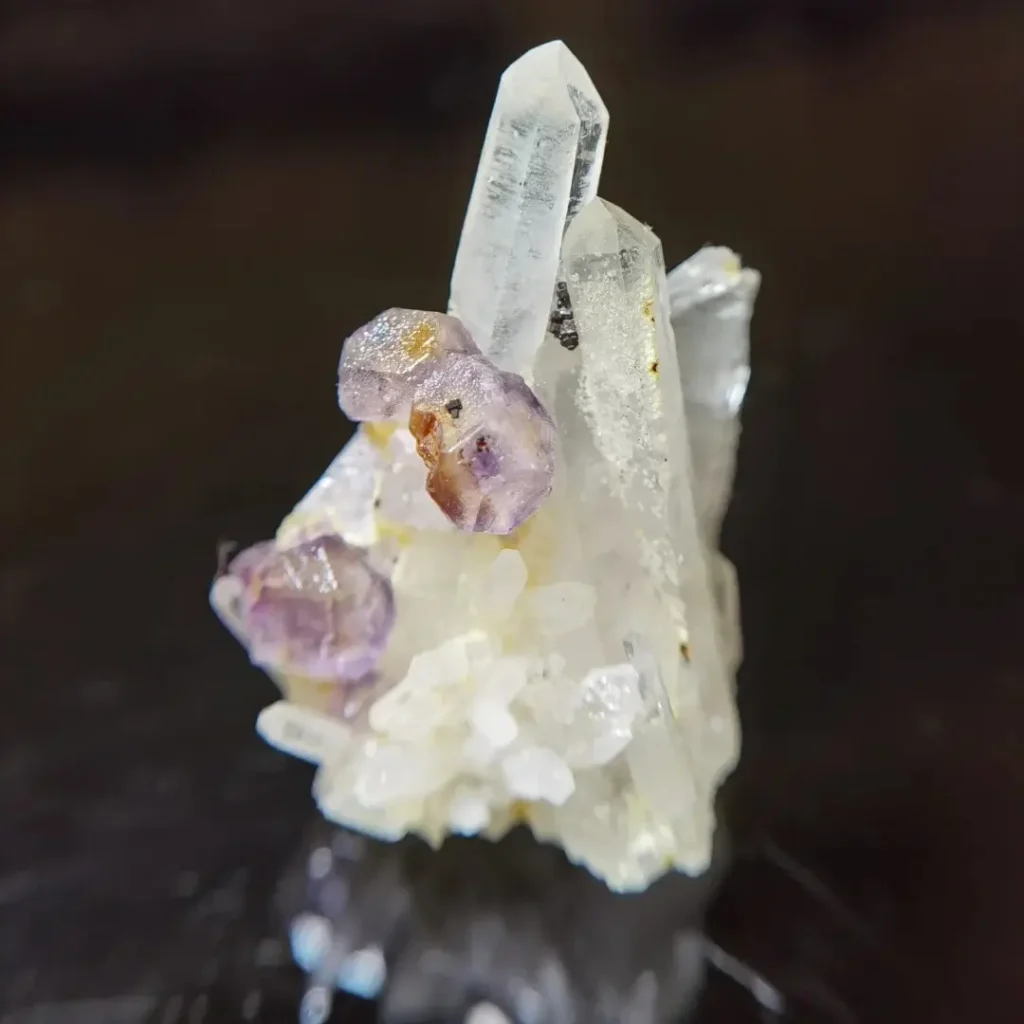 Pale purple fluorite crystals growing on a cluster of clear quartz points from Hunan.