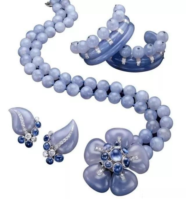 A vintage jewelry suite of light blue chalcedony beads, leaf earrings, and a large flower brooch.