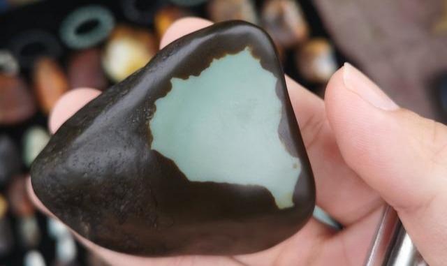 Raw Guangxi Dahua nephrite seed jade with dark brown skin and pale green core.