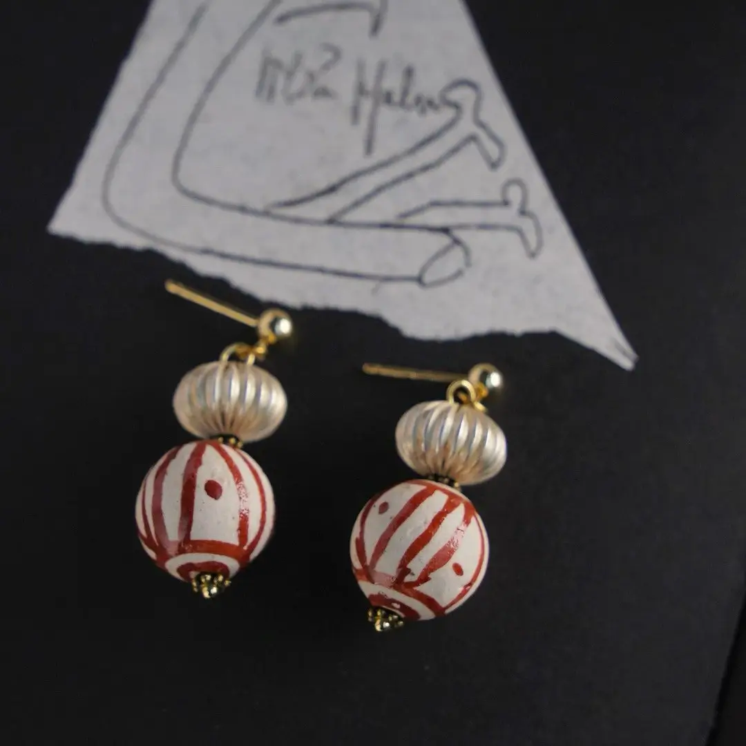 Hand-finished antique silver lantern earrings on a black background.