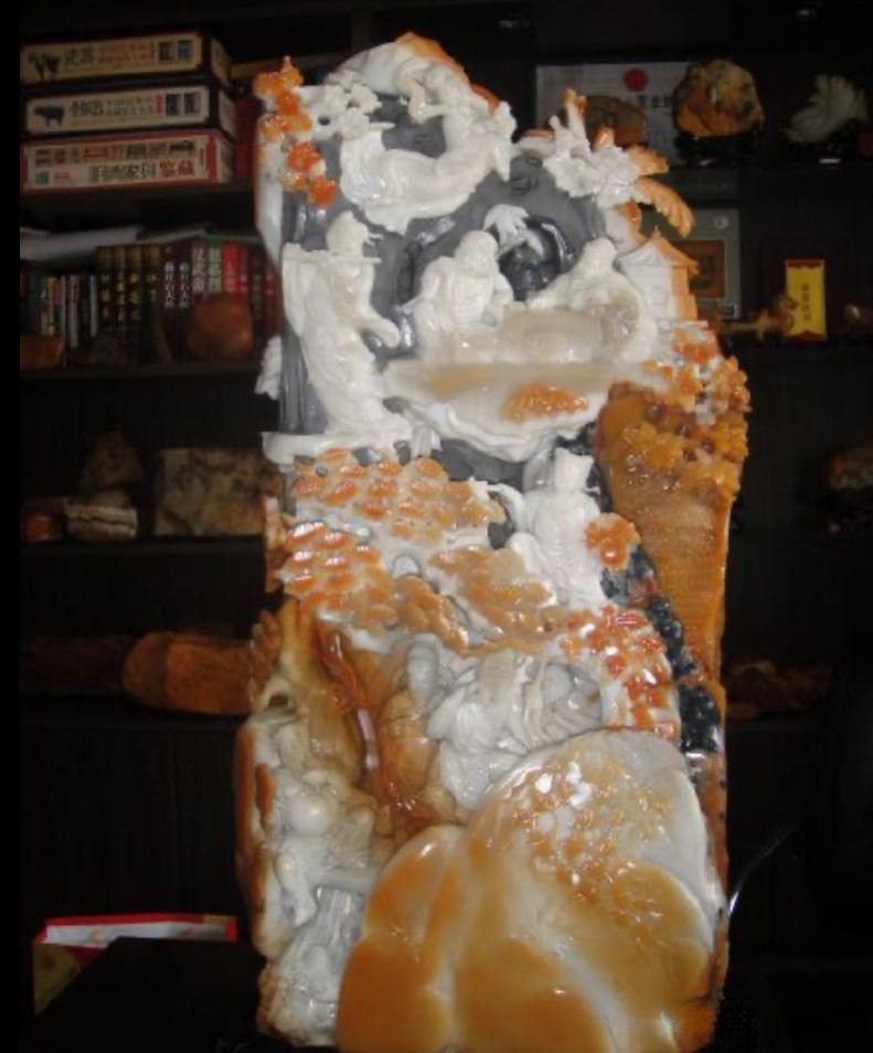 A massive Huoshan jade carving of the Eight Immortals with intricate white and honey-toned details.