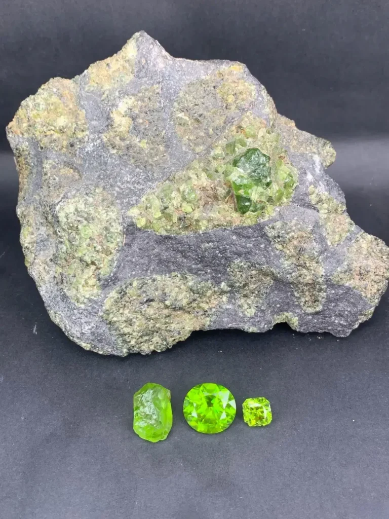Jilin peridot crystals in basalt matrix next to rough, round-cut, and square-cut green gems.