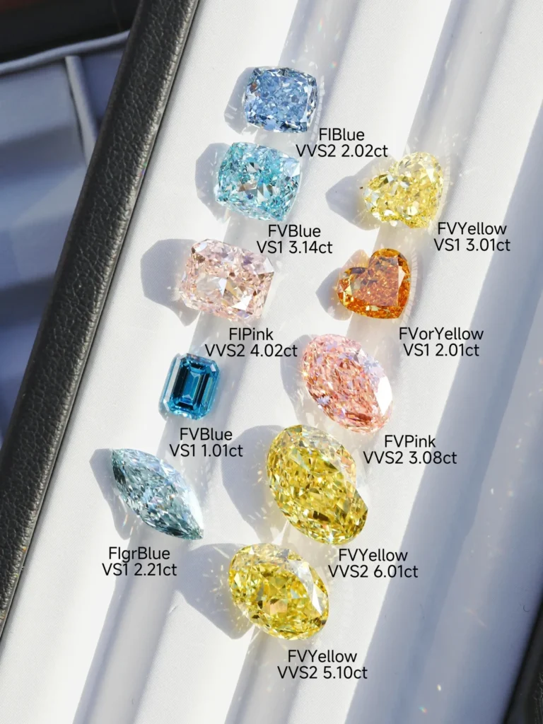 Various colorful lab diamonds with text labels showing cuts, weights, and colors inside a display case.