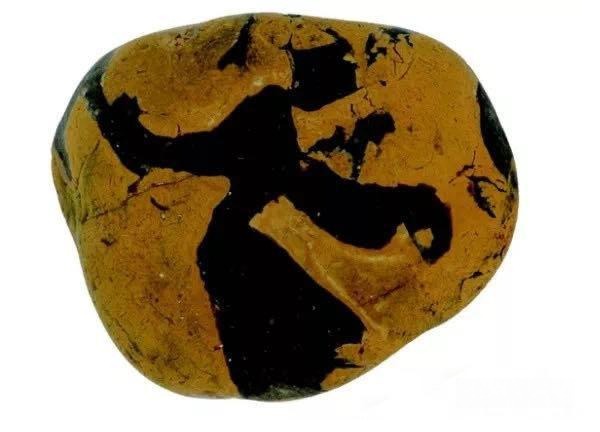 Natural Yuhua agate stone featuring a dark silhouette resembling a dancer on a yellow background.