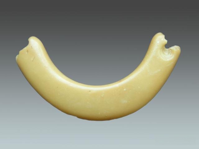 A crescent-shaped, yellowish-white Qingtian stone Huang ornament from the Neolithic Songze Culture.