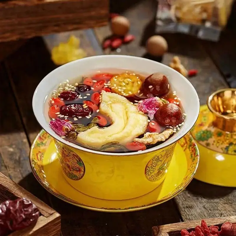 Traditional Ningxia eight-treasure tea served in a yellow lidded gaiwan with goji berries and fruit.