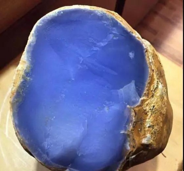 Large raw Taiwan Blue Chalcedony specimen showing a vibrant celestial blue interior within its rough brown crust.