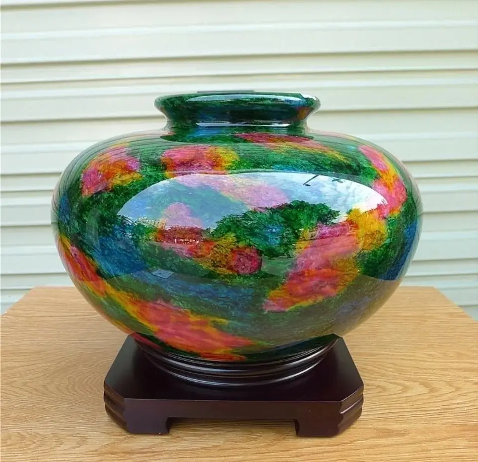 A highly polished, multicolored decorative vase displaying abstract swirls of green, red, and yellow glaze.