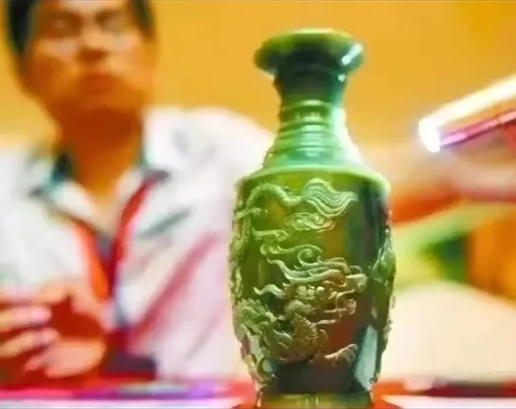 A green-cyan Chinese Xianghua nephrite jade vase carved with intricate dragon motifs.