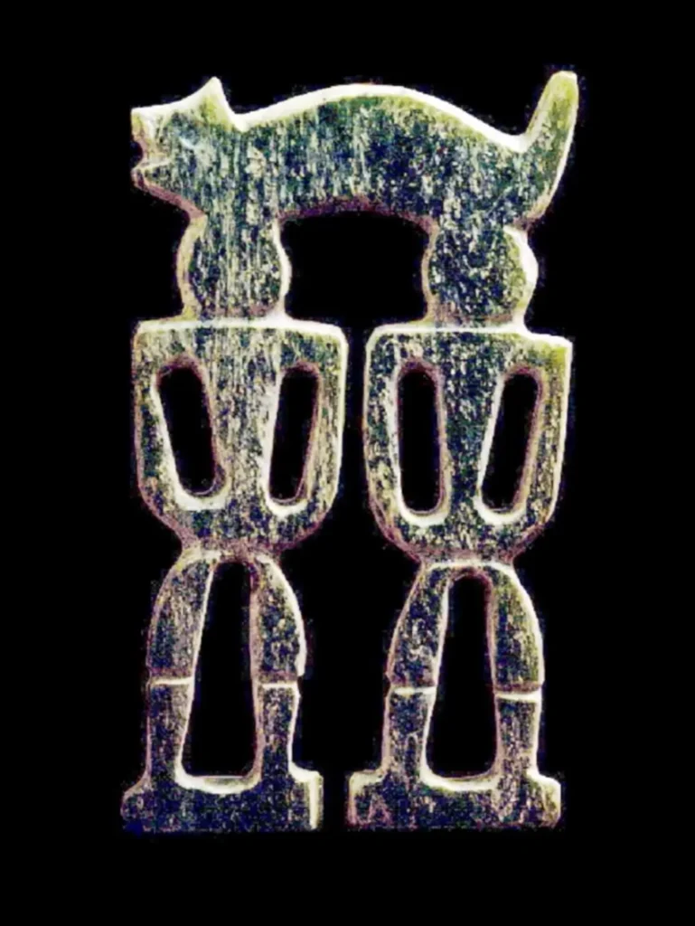 Prehistoric Taiwan Nephrite earring shaped like two stylized humans standing under a zoomorphic beast.
