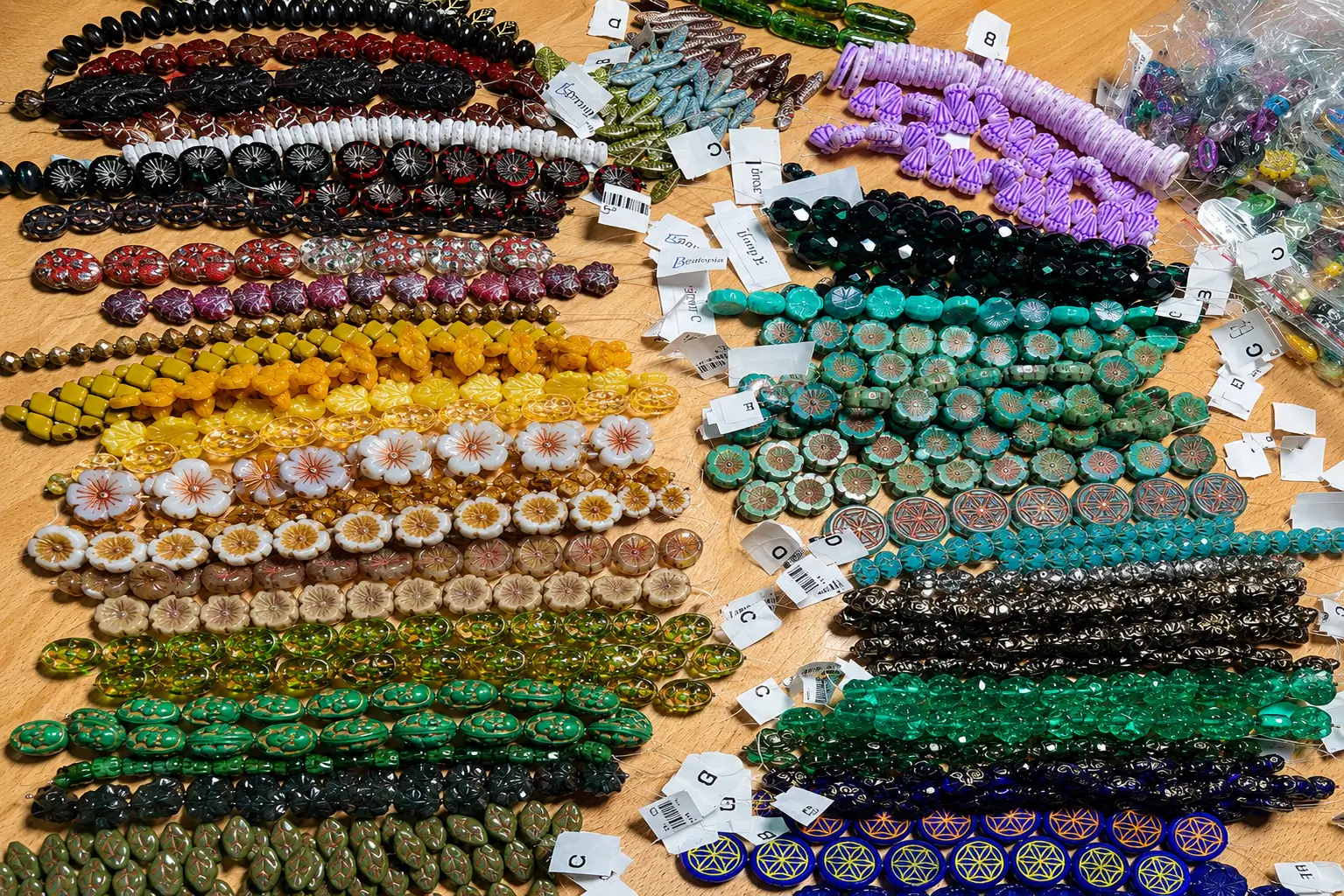 Assorted Czech glass beads arranged on a tabletop, showing multiple colors, shapes, and finishes.