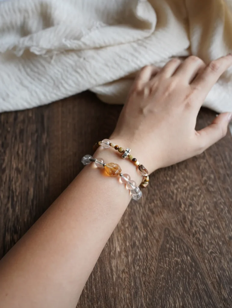 Earthy gemstone bracelet stacked with clear quartz, showing harmonious mineral colors on a wrist.