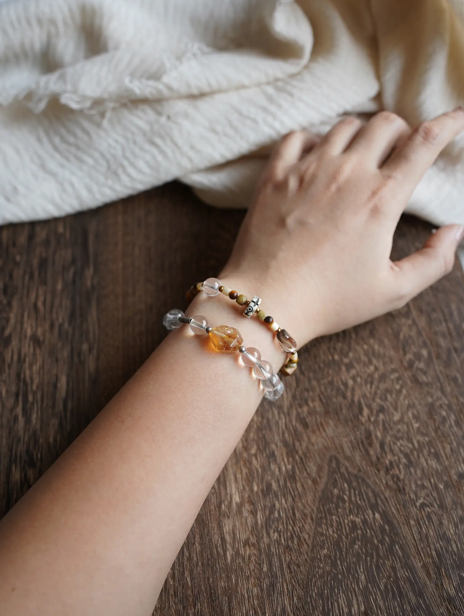 Earthy gemstone bracelet stacked with clear quartz, showing harmonious mineral colors on a wrist.