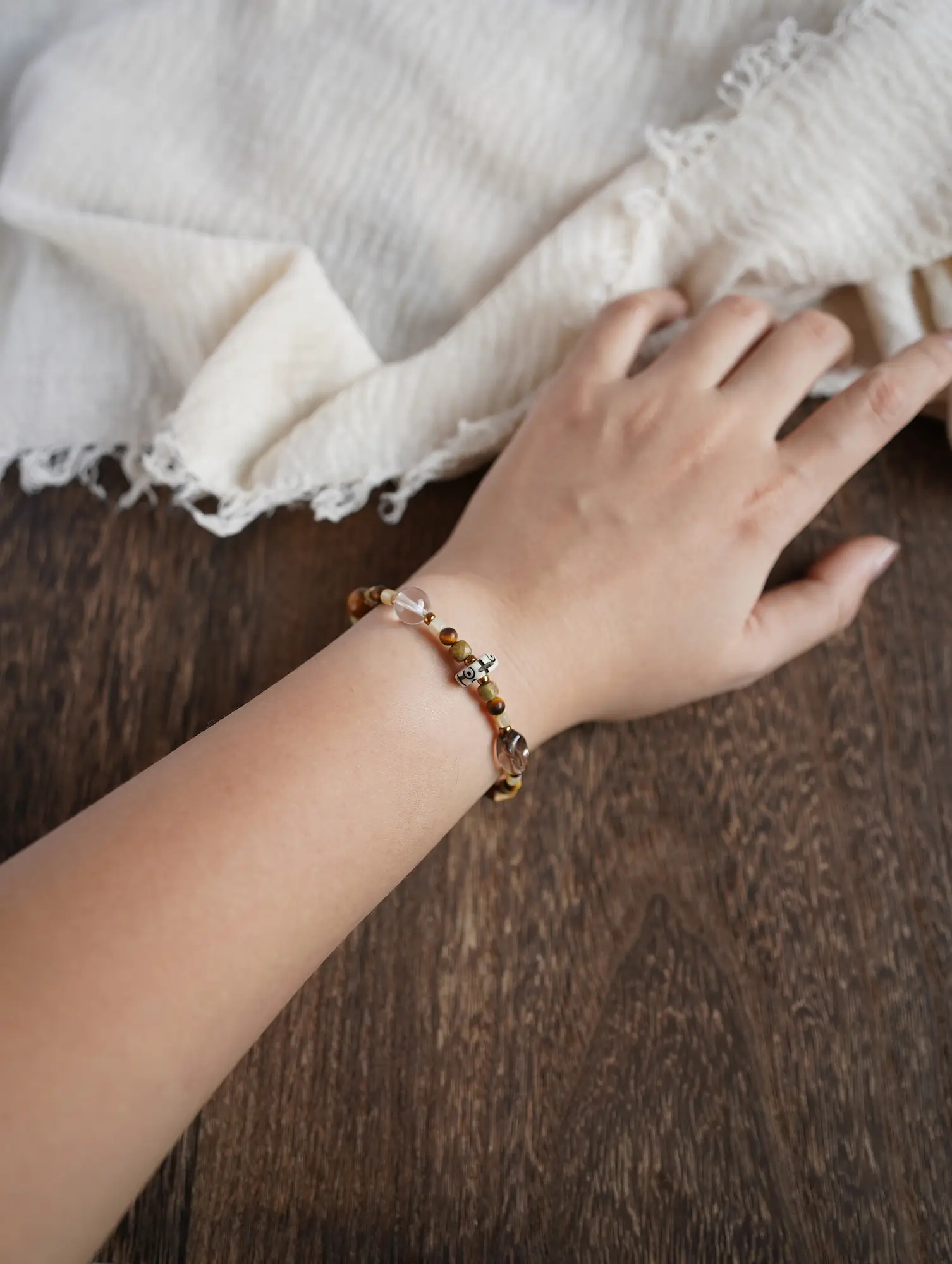 Wrist view of a gemstone bracelet showing natural drape and mineral alignment on the hand.