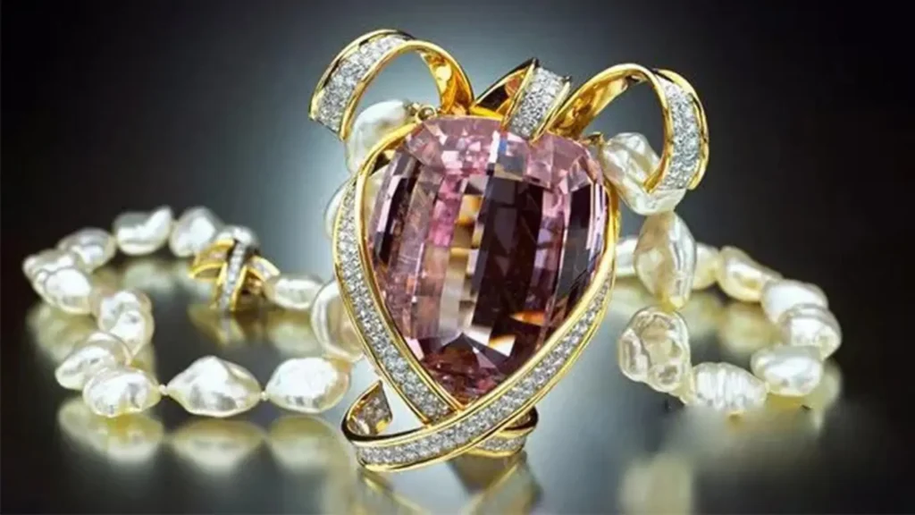 A 396.30-carat pink kunzite pendant surrounded by diamonds, set on a baroque pearl strand.