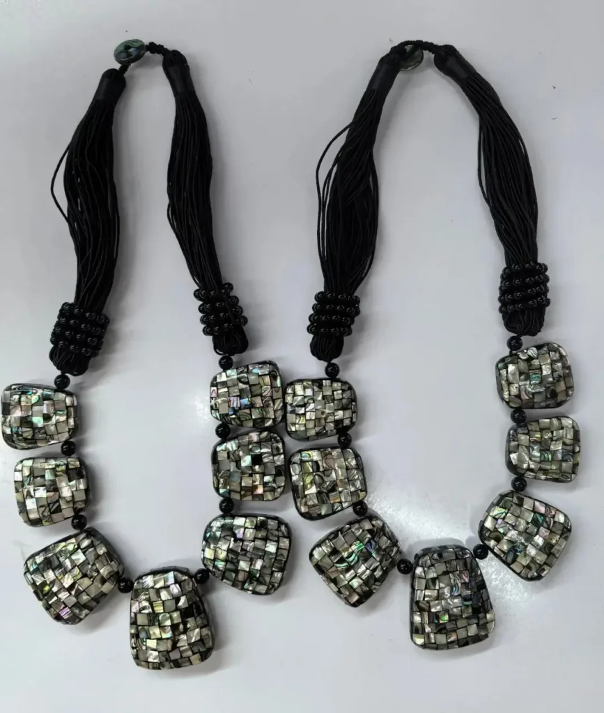 Two shell jewelry necklaces featuring geometric panels with iridescent abalone shell mosaic inlay.
