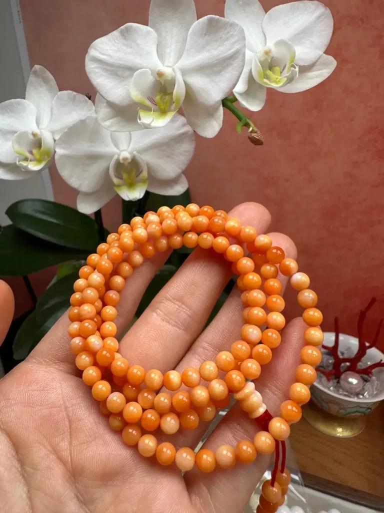 Blood red Tridacna shell prayer beads with polished orange-red beads and warm luster.