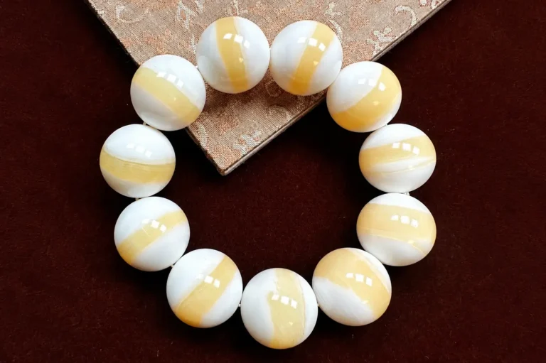 Gold-Thread Tridacna shell bracelet with natural golden-brown patterns on ivory beads.